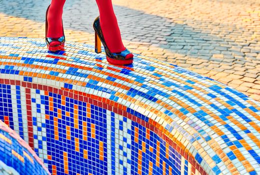 Fashion urban womens legs, pantyhose, stylish heels. Multicolored geometry square mosaic. Trendy shoes, creative, outdoor