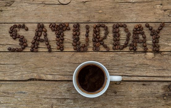Cup of coffee on wooden background and Saturday coffee beans