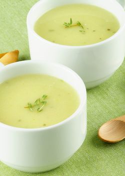 Delicious Cream Asparagus Soup in Two White Soup Cups Cross Section on Green Napkin