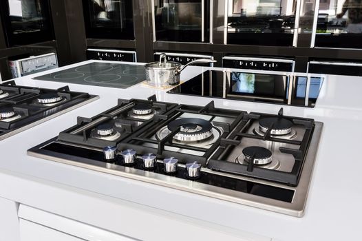 Rows of gas stoves with stainless tray selling in appliance retail store