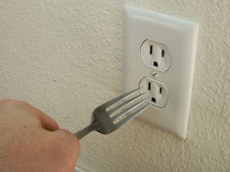 This is dangerous. Do not put metal into a wall outlet