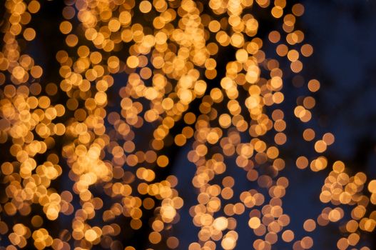 Defocused of glitter or gold bokeh circle at night as background.