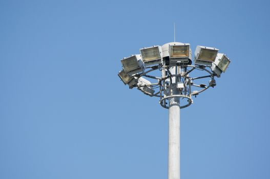 Lamps on high pole at super highway with blue sky.