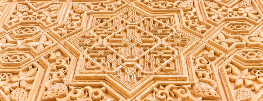 Wall detail of Alhambra UNESCO site in Granada - South of Spain. 600 years old arabic characters.