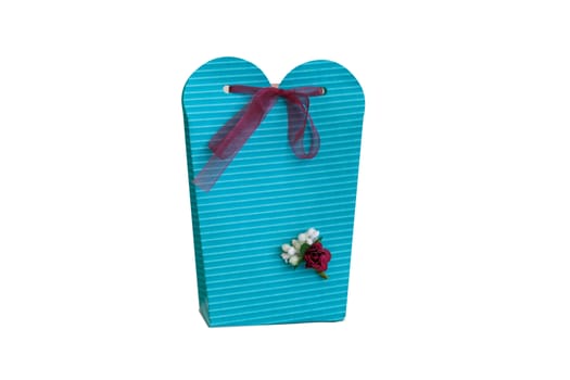 Close up detailed front view of hand-crafted green gift box with small flowers and colorful ribbons, isolated on white background.