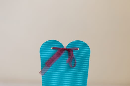 Close up detailed front view of hand-crafted green gift box with colorful ribbons.