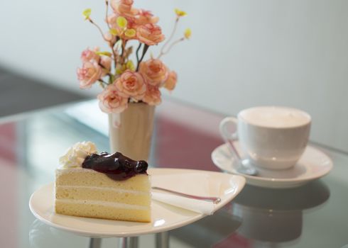 Blueberry cake with cup of coffee on table at restaurant.