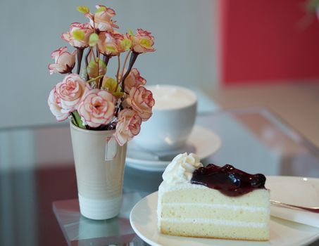 Blueberry cake with cup of coffee on table at restaurant.