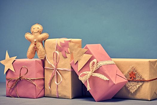 Gift boxes, Christmas decorations. Gingerbread men made of felt, paper fir tree, star. Greeting card, handmade, closeup