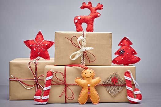Gift boxes, Christmas decorations. Gingerbread men, candy cane, reindeer, fir tree star made of felt. Greeting card, handmade, closeup