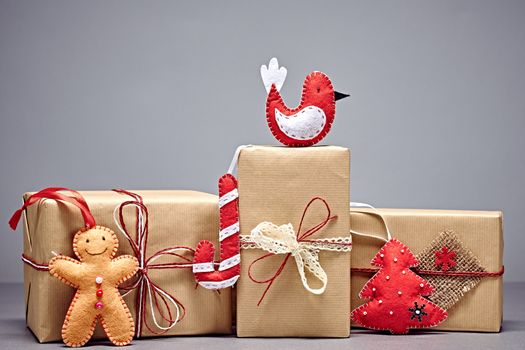 Gift boxes, Christmas decorations. Gingerbread men, candy cane, fir tree star made of felt. Greeting card, handmade, closeup