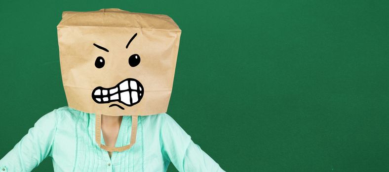 Woman covering head with brown paper bag  against green