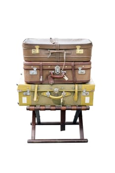 Old suitcases travel resting on a wooden stool and isolated on white background.