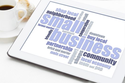small business word cloud on a digital tablet with a cup of coffee