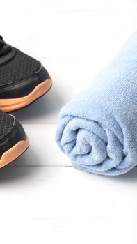 running shoes and towel on white wood table