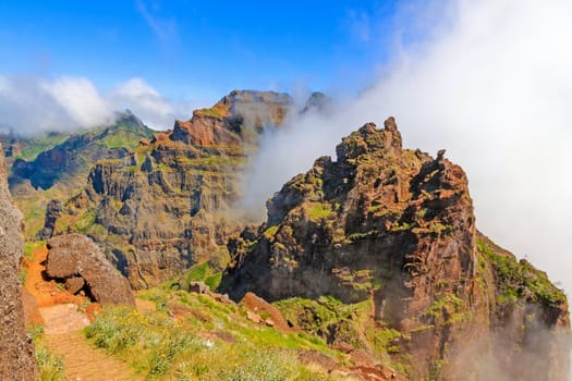 Colorful volcanic mountain landscape with clouds - hiking path from Pico do Arieiro to Pico Ruivo, Madeira, Portugal