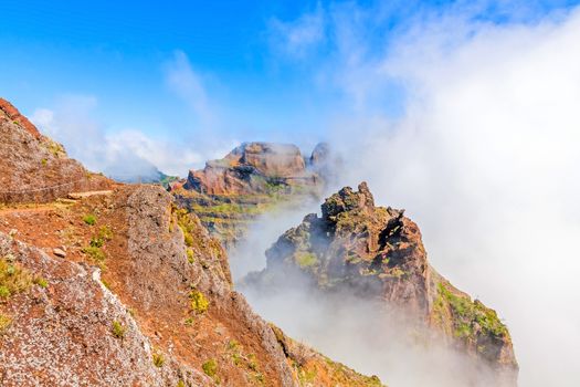 Colorful volcanic mountain landscape with clouds - hiking path from Pico do Arieiro to Pico Ruivo, Madeira, Portugal