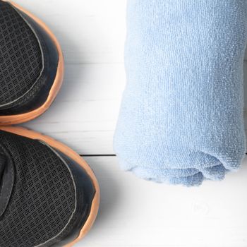 running shoes and towel on white wood table