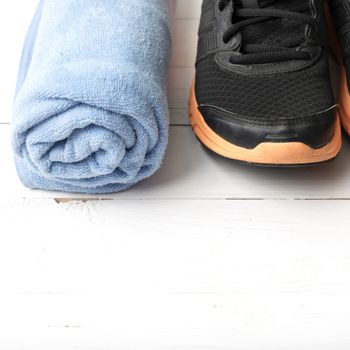 running shoes and towel on white wood table