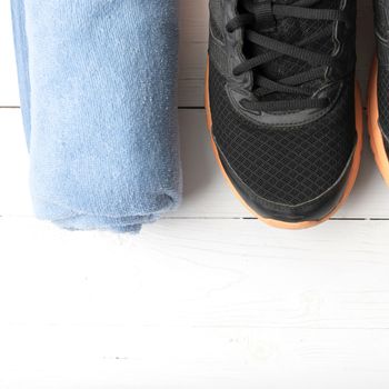 running shoes and towel on white wood table