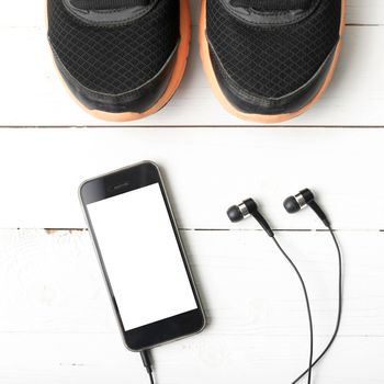 running shoes and phone on white wood table