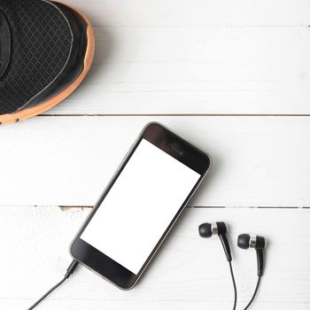 running shoes and phone on white wood table