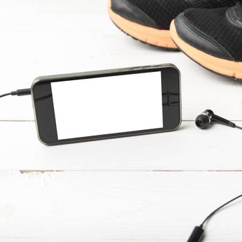 running shoes and phone on white wood table