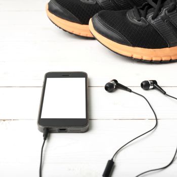 running shoes and phone on white wood table