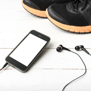 running shoes and phone on white wood table