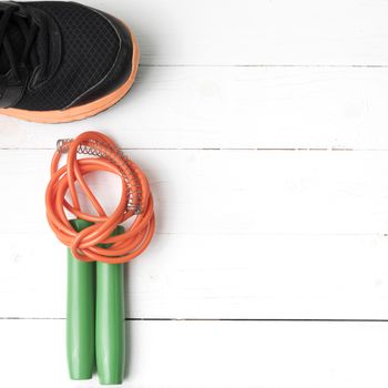 fitness equipment : running shoes,jumping rope on white wood table