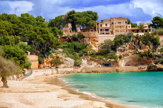 Sea side villas over the sand beach in Cala Mandrago, Mallorca island, Spain