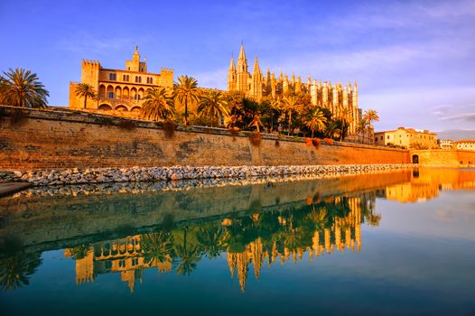 Gothic cathedral La Seu in Palma de Mallorca, Spain, reflecting in the lake water in sunset light