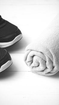 running shoes and towel on white wood table black and white tone color style