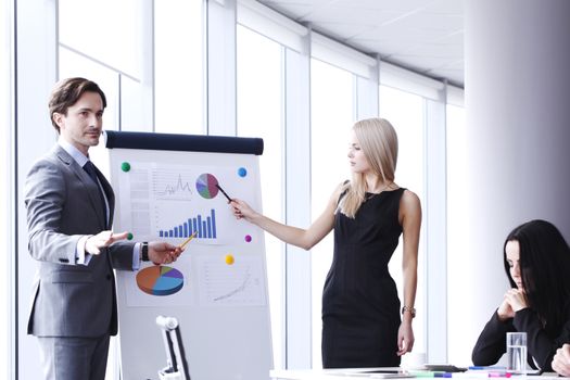 Workers at business meeting looking at presentation of financial reports in modern office