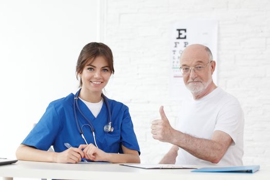 Happy senior patient with new glasses in ophthalmologist office