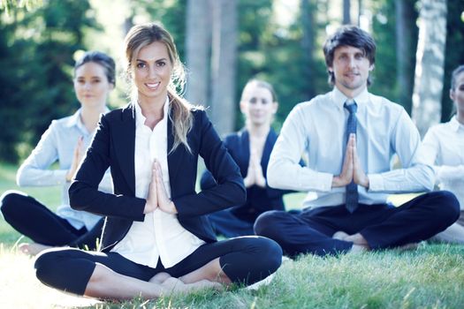 Business people practicing yoga in park