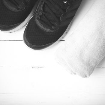 running shoes and towel on white wood table black and white tone color style