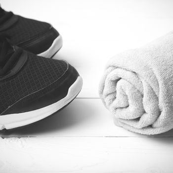 running shoes and towel on white wood table black and white tone color style