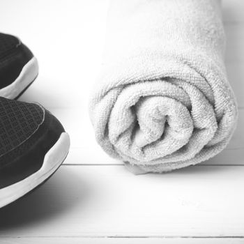 running shoes and towel on white wood table black and white tone color style