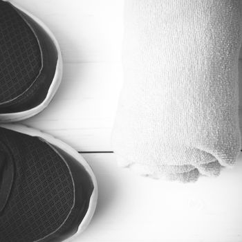 running shoes and towel on white wood table black and white tone color style