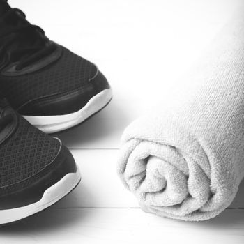 running shoes and towel on white wood table black and white tone color style