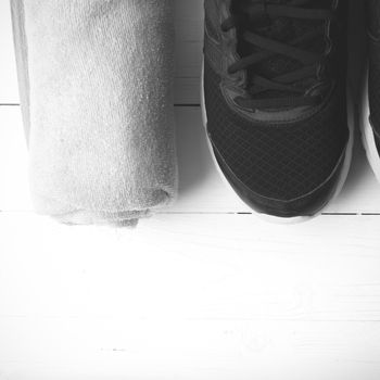 running shoes and towel on white wood table black and white tone color style