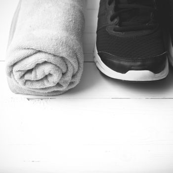 running shoes and towel on white wood table black and white tone color style