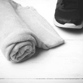 running shoes and towel on white wood table black and white tone color style