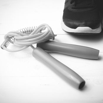 running shoes and jumping rope on white table black and white tone color style