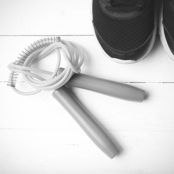 running shoes and jumping rope on white table black and white tone color style