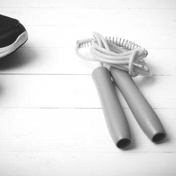 running shoes and jumping rope on white table black and white tone color style
