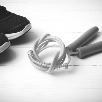 running shoes and jumping rope on white table black and white tone color style