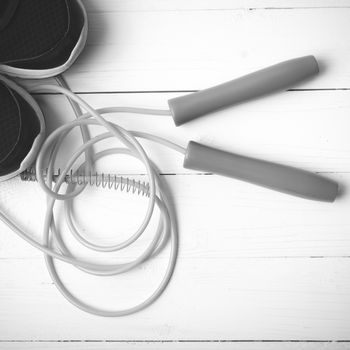 running shoes and jumping rope on white table black and white tone color style