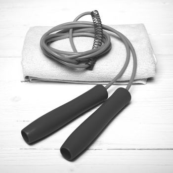 fitness equipment:white towel,jumping rope on white wood table black and white color style